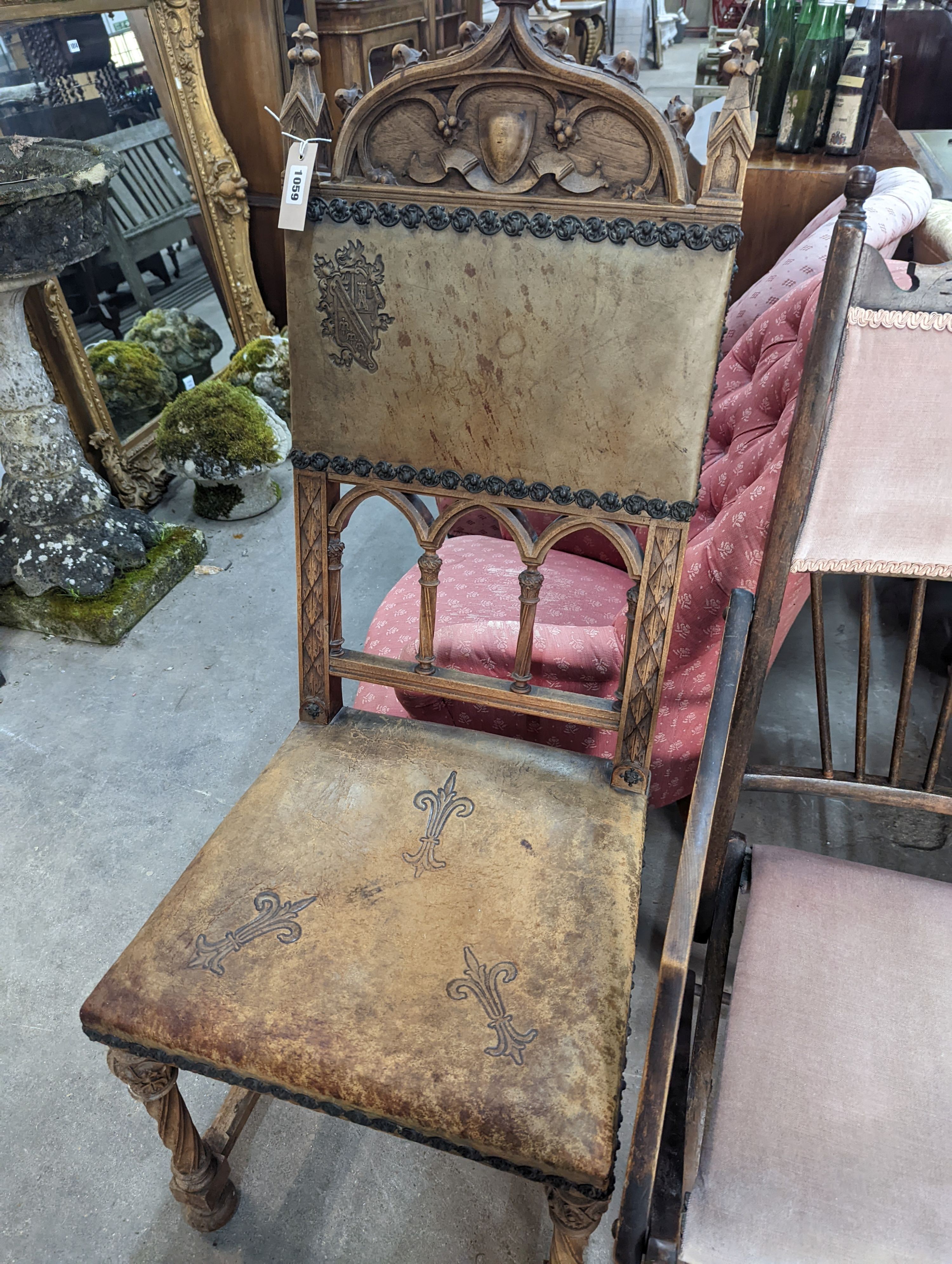 A pair of Gothic style carved walnut and leather side chairs together with an Edwardian beech folding chair
